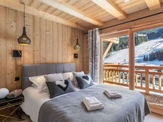 Wake up to breathtaking mountain views from this luxurious chalet bedroom.