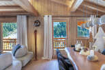 This stunning chalet boasts a spacious open-plan living area with floor-to-ceiling windows offering breathtaking mountain views.