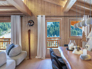 This stunning chalet boasts a spacious open-plan living area with floor-to-ceiling windows offering breathtaking mountain views.