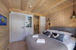 This luxurious chalet bedroom boasts a stunning wood-paneled interior, creating a warm and inviting atmosphere.