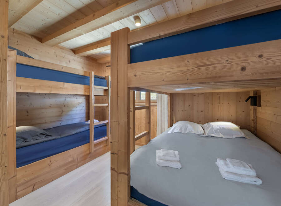 Cozy wooden bunk beds with blue bedding and a light grey duvet, perfect for a family getaway.
