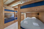 Cozy wooden bunk beds with blue bedding and a light grey duvet, perfect for a family getaway.