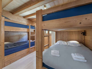 Cozy wooden bunk beds with blue bedding and a light grey duvet, perfect for a family getaway.