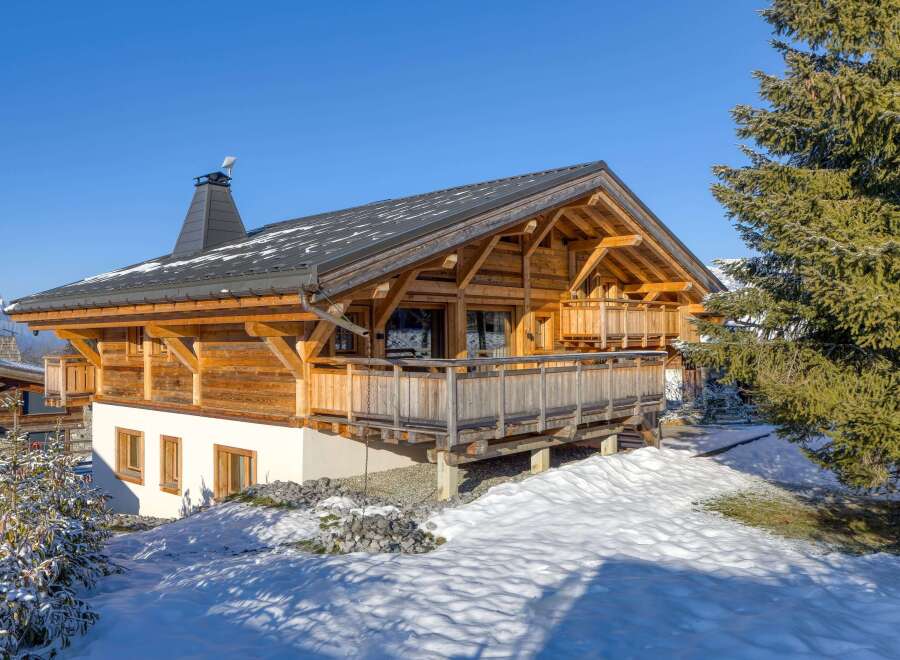Discover the charm of this stunning wooden chalet nestled in a snowy landscape.