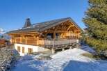 Discover the charm of this stunning wooden chalet nestled in a snowy landscape.