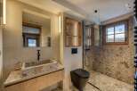 This luxurious bathroom features a stunning stone sink and countertop, complemented by a sleek black faucet.