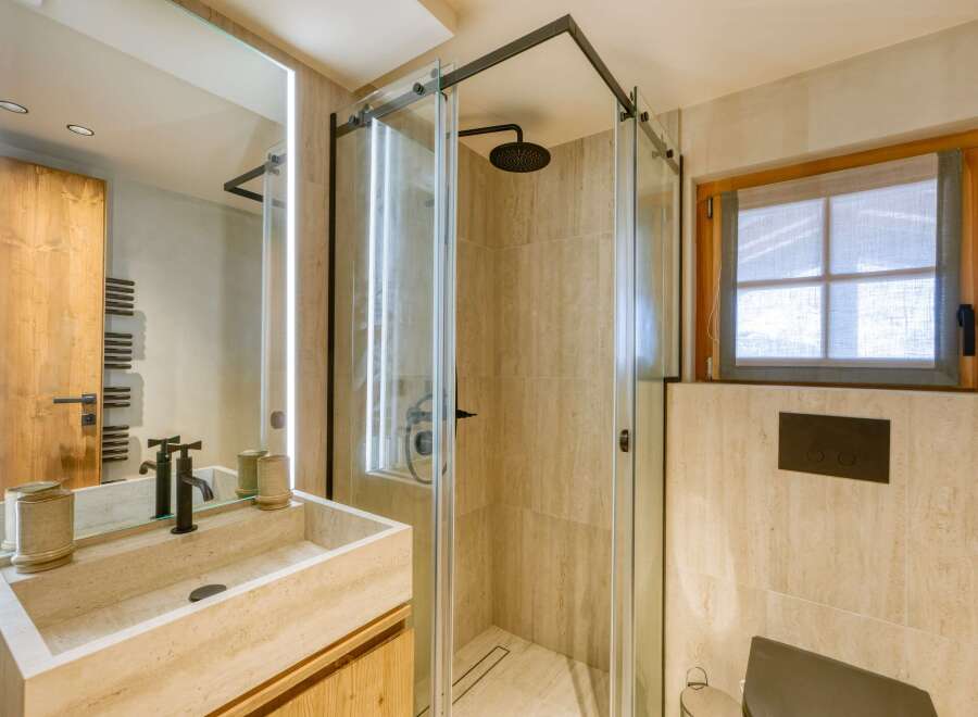 This luxurious bathroom features a sleek, modern design with a spacious walk-in shower and elegant fixtures.