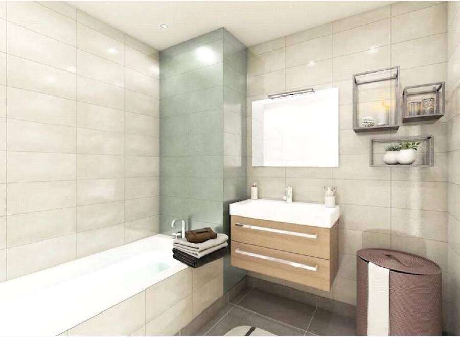 Modern bathroom with light beige tiles, a built-in bathtub, and a floating vanity with two drawers.
