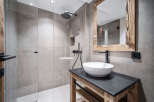 Modern bathroom with a walk-in shower and a rustic wooden vanity.