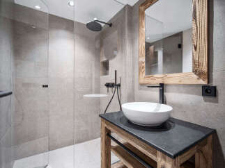 Modern bathroom with a walk-in shower and a rustic wooden vanity.