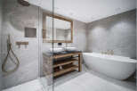Luxury bathroom with a freestanding bathtub and a walk-in shower, featuring modern fixtures and a rustic wooden vanity.