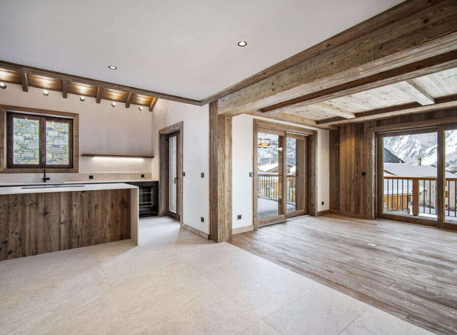 This stunning chalet boasts a spacious open-plan living area with floor-to-ceiling windows offering breathtaking mountain views.