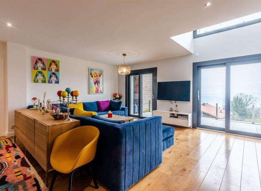 Stunning lake view from this modern home's expansive windows and sliding glass doors.