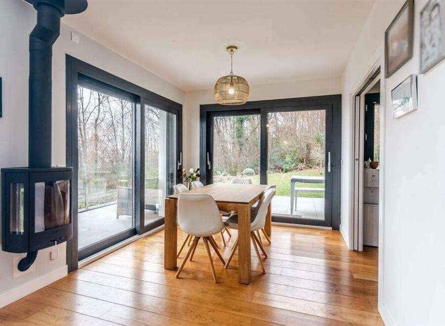 This stunning property boasts a spacious dining area with large sliding glass doors that offer breathtaking views of the garden.