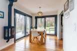 This stunning property boasts a spacious dining area with large sliding glass doors that offer breathtaking views of the garden.