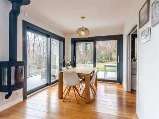 This stunning property boasts a spacious dining area with large sliding glass doors that offer breathtaking views of the garden.