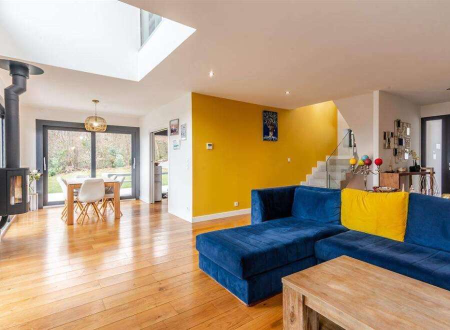 Stunning open-plan living space with hardwood floors and a modern wood-burning stove.