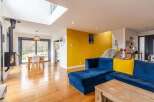 Stunning open-plan living space with hardwood floors and a modern wood-burning stove.