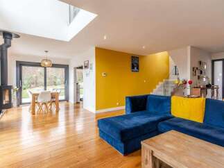 Stunning open-plan living space with hardwood floors and a modern wood-burning stove.