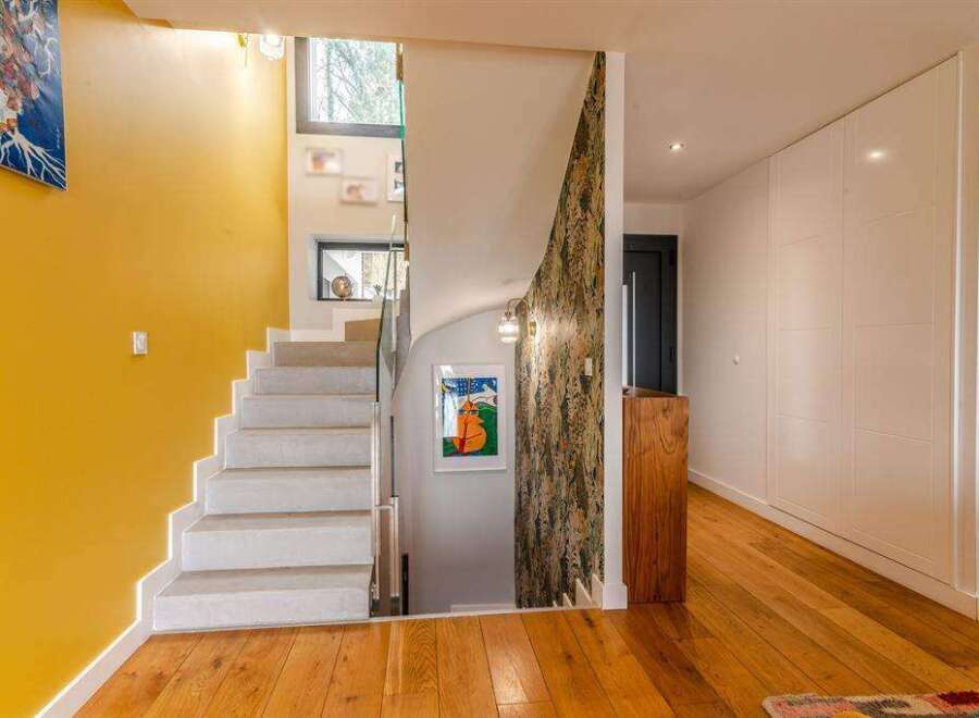 Stunning modern home showcasing a bright, open-concept design with a contemporary staircase and hardwood floors.