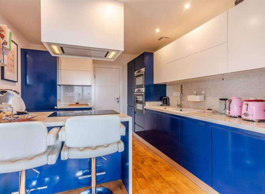 Stunning modern kitchen with sleek blue cabinetry and white countertops.