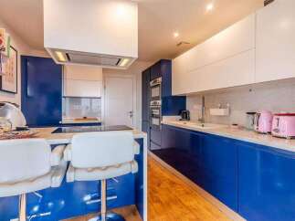 Stunning modern kitchen with sleek blue cabinetry and white countertops.