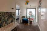 This stunning property boasts a spacious hallway with a unique patterned wall, plush seating area, and large windows offering breathtaking views.