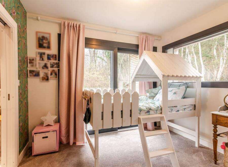 Charming child's bedroom with a unique house-shaped bed, creating a whimsical and playful atmosphere.