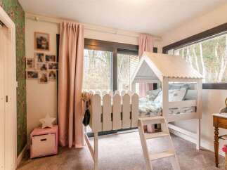 Charming child's bedroom with a unique house-shaped bed, creating a whimsical and playful atmosphere.