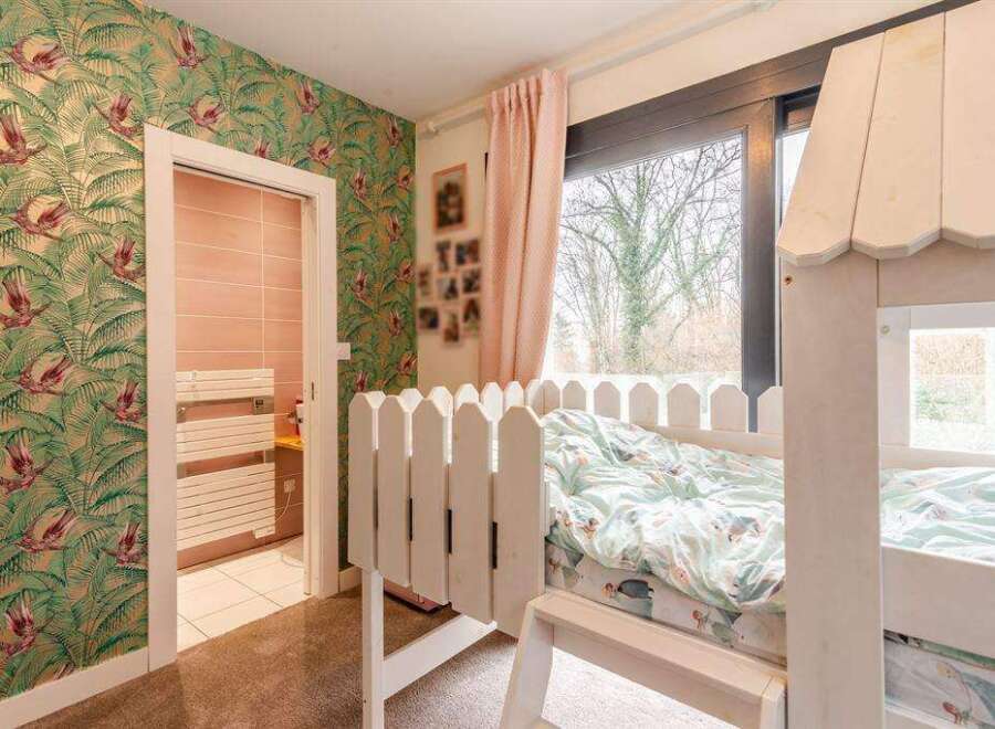 Charming child's bedroom with custom bunk bed and tropical wallpaper.