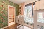 Charming child's bedroom with custom bunk bed and tropical wallpaper.