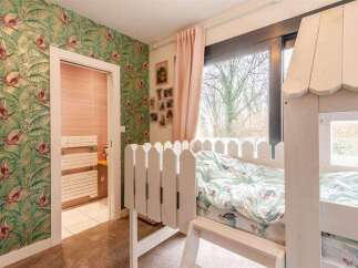 Charming child's bedroom with custom bunk bed and tropical wallpaper.