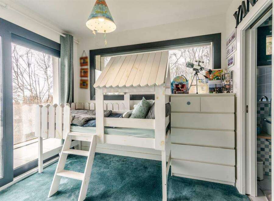 Charming child's bedroom with built-in bunk bed, ample storage, and sliding door access to bathroom.