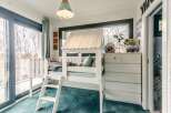 Charming child's bedroom with built-in bunk bed, ample storage, and sliding door access to bathroom.