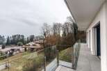 Modern balcony with glass railings offering panoramic views of the surrounding landscape.