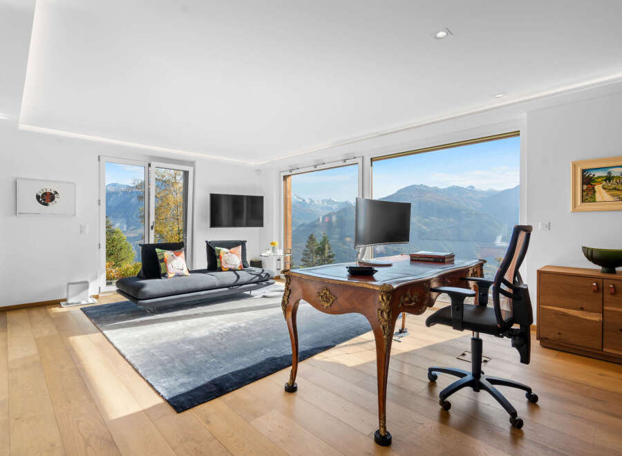 This stunning home office boasts breathtaking panoramic mountain views through expansive windows, creating a serene and inspiring workspace.