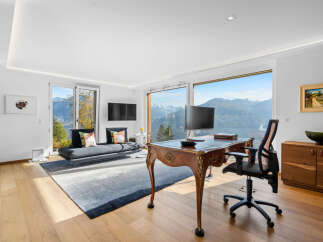 This stunning home office boasts breathtaking panoramic mountain views through expansive windows, creating a serene and inspiring workspace.