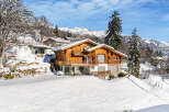 Experience the epitome of alpine living in this stunning wooden chalet nestled amidst a snowy landscape.