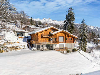 Experience the epitome of alpine living in this stunning wooden chalet nestled amidst a snowy landscape.