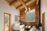 Experience the charm of this stunning property, featuring a cozy living room with a unique fireplace and a beautiful wooden ceiling.