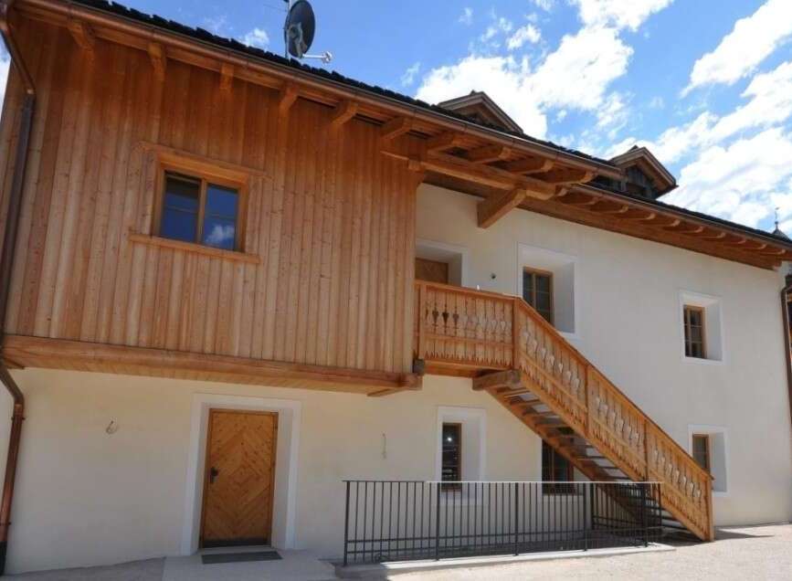 Discover the charm of this stunning property, featuring a unique wooden facade and a beautifully crafted staircase.