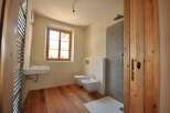 This charming bathroom features a rustic wooden floor and a bright window that fills the space with natural light.