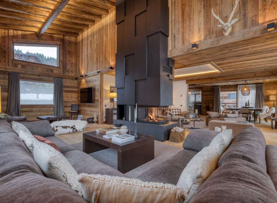 Experience luxury living in this stunning chalet, featuring a grand fireplace and exquisite wooden accents throughout.