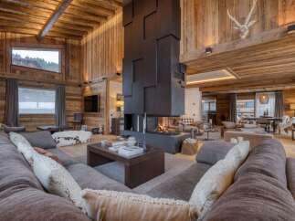 Experience luxury living in this stunning chalet, featuring a grand fireplace and exquisite wooden accents throughout.