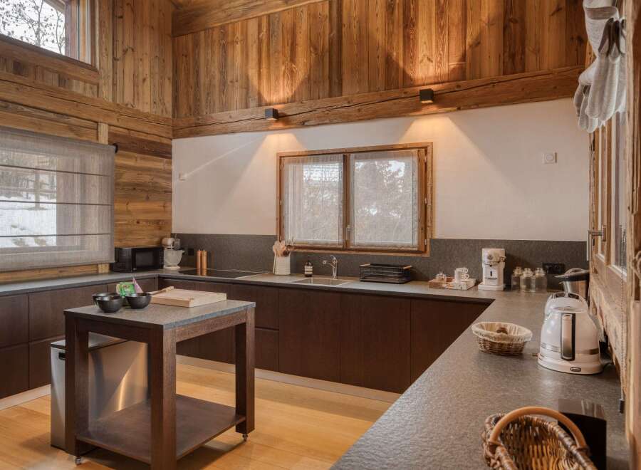 This stunning kitchen boasts a rustic charm with its wooden walls and ceiling, creating a warm and inviting atmosphere.