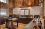 This stunning kitchen boasts a rustic charm with its wooden walls and ceiling, creating a warm and inviting atmosphere.