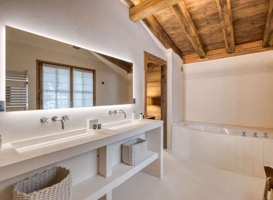 This luxurious bathroom features a stunning wooden ceiling and a spacious vanity with double sinks.