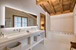 This luxurious bathroom features a stunning wooden ceiling and a spacious vanity with double sinks.