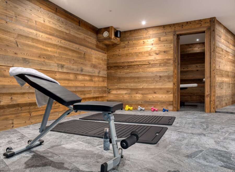 This home gym features a rustic, wood-paneled interior, creating a warm and inviting workout space.