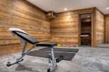 This home gym features a rustic, wood-paneled interior, creating a warm and inviting workout space.